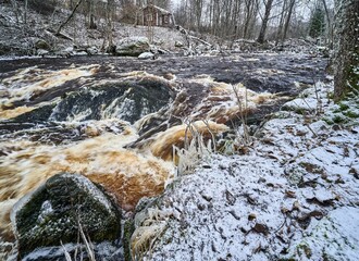 a stream with brown and white water flowing through it in the winter: Vantaa
