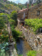 Water da Galega stream between backyard walls and schist houses in Água Formosa village, Vila de Rei PORTUGAL