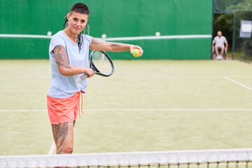 Woman with prosthetic leg engaging in tennis game on court, showing determination and focus