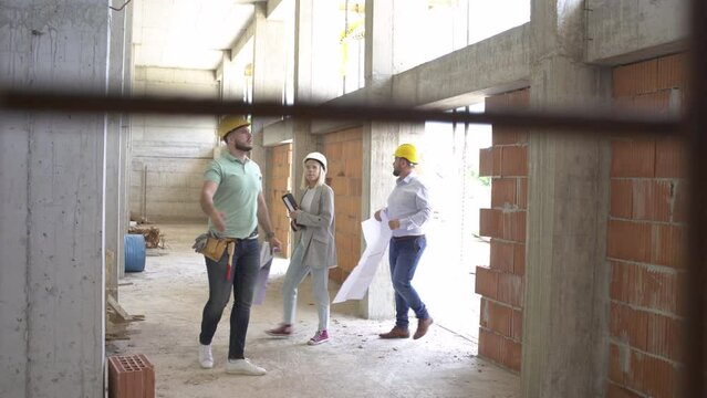 A female architect and construction manager work together on-site, discussing blueprints and coordinating to bring their project to life.