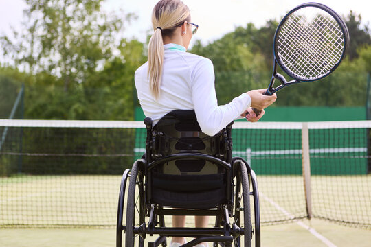 Woman using wheelchair playing tennis, showcasing sports inclusion and adaptability