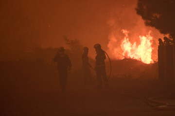 Fototapeta premium Firemen extinguishing the fire during night