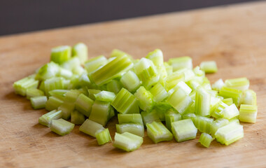 Chopped Celery Cubes on Wooden Board Close Up