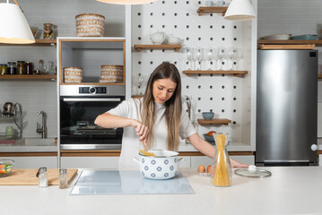 Cooking - Young woman with spaghetti on stove cooking Italian cuisine. University student or...