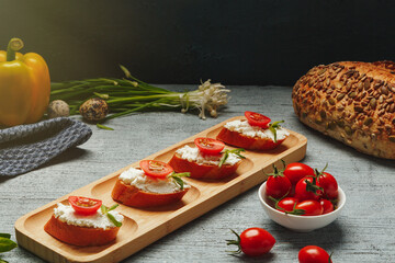 Bruschetta sandwiches with cottage cheese and tomato for lunch. A healthy snack for people on a...