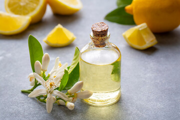 Fresh citrus essential oil. Lemon oil bottle with lemons fruits