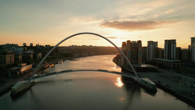 Drone flies backwards over River Tyne from Millennium Bridge and Baltic centre in a stunning autumn dawn 