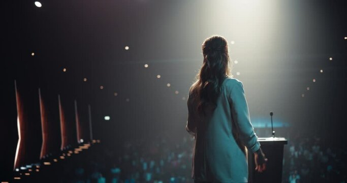 Caucasian Female Speaker with Expertise in Technology, Finance, Business, Politics, and Religion Coaching a Diverse Group of Young Specialists During a Presentation at a Strategic Growth Conference