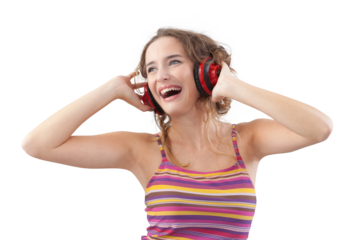 Portrait of young joyful woman who is listening to music through red headphones, looks to the side with her blue eyes, while being isolated on a white background