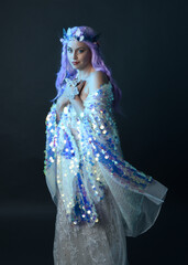 artistic portrait of beautiful female model with long purple hair wearing a fantasy fairy crown,...