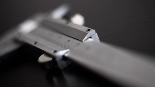 Measuring device. Slide caliper in a blue box. The man opens a box with the appliance. Decimal system of measurements. Accuracy of measurements. 4K. Calipers.