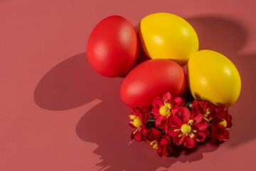 Colorful eggs, symbolizing Easter, on a colorful background and flowers