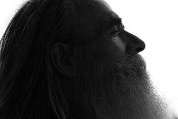 A dark profile portrait of a bearded man with closed eyes