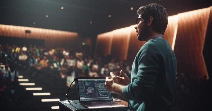 South Asian Software Developer Using Laptop Computer and Delivering a Motivational Speech on Stage, Hosting a Seminar to Help Entrepreneurs Overcome Their Personal and Professional Challenges