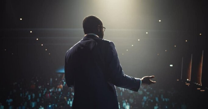 African Businessman Speaking at a Global Economic Strategies at International Business Conference. Public Speaker Sharing Professional Knowledge and Leadership Insights. Footage from Behind
