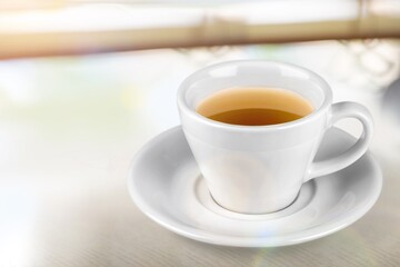 cup of tasty hot green tea on desk background