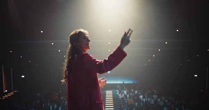 Celebrity Public Speaker Giving an Inspiring Talk at an International Business Development Conference. Female Using a Headset Microphone to Deliver a Strong Message and Coaching Advice