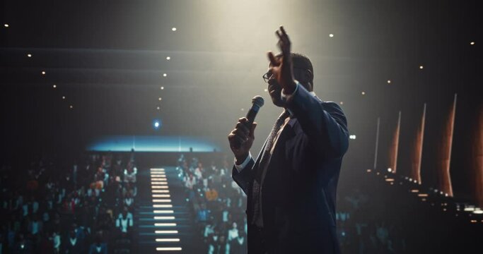 Celebrity Public Speaker Giving an Inspiring Talk at an International Business Development Conference. African Man Using a Microphone to Deliver a Strong Message and Coaching Advice
