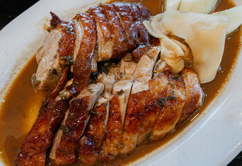 Asian food, roasted duck or BBQ duck in Chinese style cooking, close-up Chinese Roasted Duck on a white plate, natural light.