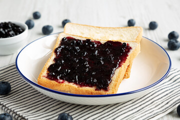 Homemade Blueberry Jam and Toast on a Plate, side view.