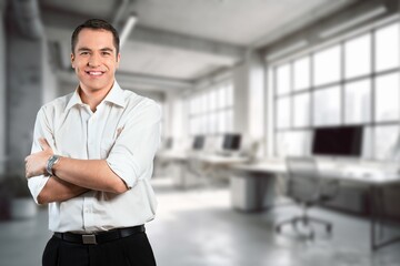 Happy proud professional businessman standing in office