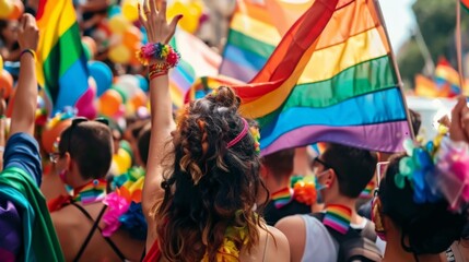 Crowd celebrating with rainbow flags at a public event