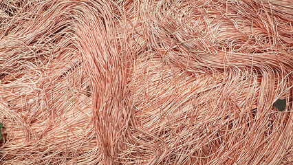 Macro texture of tangled copper wire shavings creating a dense metallic mesh with natural hues.