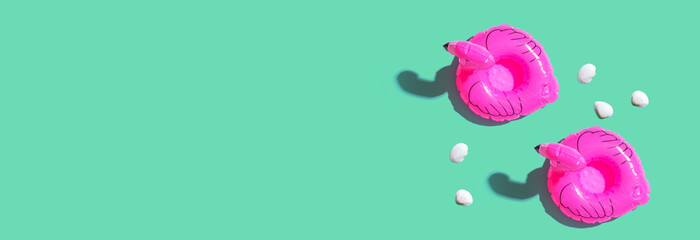 Summer concept with pink flamingo floats - flat lay