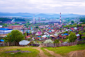 panorama of the private sector of the ancient city of Beloretsk against the backdrop of the Ural Mountains and the metallurgical plant