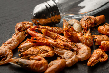 Dried shrimps with salt on black background