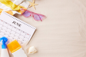 Flat lay of a June calendar with sunglasses, sunscreen, and beach backdrop, ideal for content on summer vacation planning