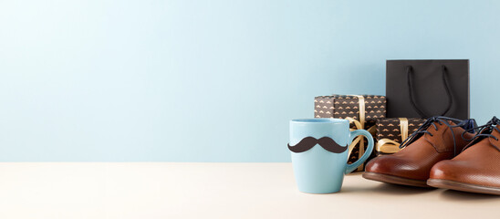 Side view of a Father's Day gift setup including a mustache mug, elegant brown shoes, and gift boxes, suitable for promotional content and advertising