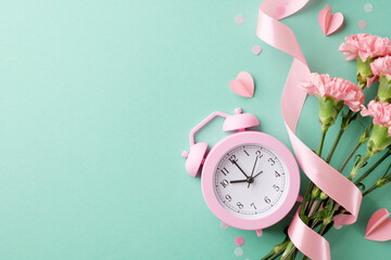 Playful and vibrant setup with a pink alarm clock and fresh carnations, perfect for content related to time management, morning routines, or spring themes