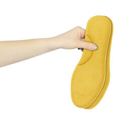 orthopedic shoe insoles in hand, outstretched hand with shoe insoles isolated from background