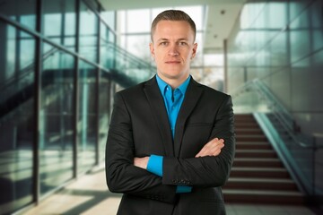 Smiling professional business man standing in office