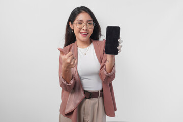Excited Asian woman wearing eyeglasses gives thumbs up hand gesture of approval while showing copy...