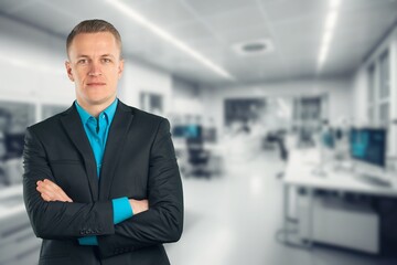 Smiling professional business man standing in office