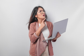 Thoughtful young Asian business woman in eyeglasses with a laptop thinking about work, isolated by white background.
