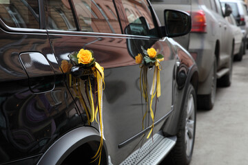 The car is decorated with gold ribbons and roses for the occasion.