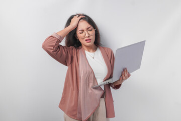 Overworked young Asian business woman holding a laptop hand on head feeling stressful, isolated by white background.