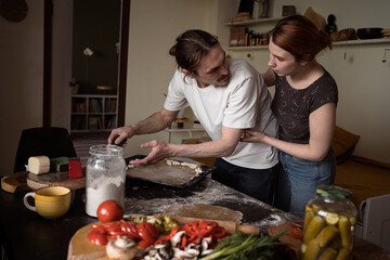 Real couple in love making food at home together