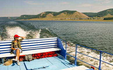 beautiful young woman on a pleasure boat on the Nugush reservoir in the Southern Urals on a summer sunny day