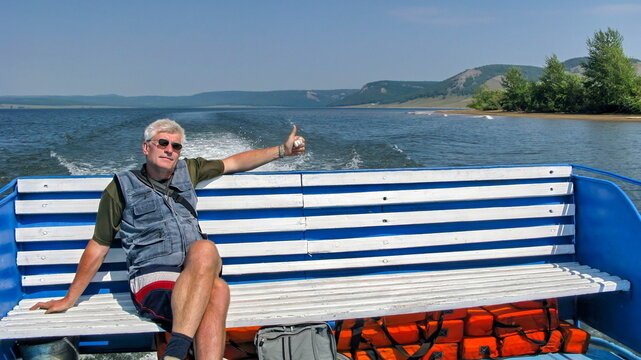 beautiful man on a pleasure boat on the Nugush reservoir in the Southern Urals on a summer sunny day