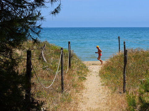 Persona che corre sulla spiaggia selvaggia nei primi giorni di estate in una giornata soleggiata