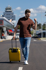 young boy walks with his suitcase happy