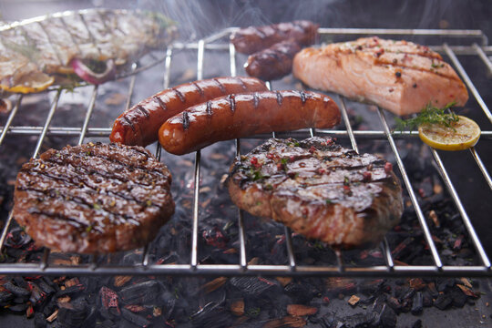 Grilled meat, sausage and fish on a grill grate