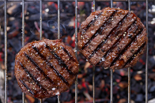 Grilled burger patties on a grill rack
