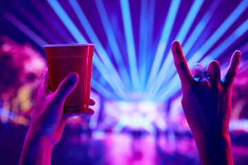 Rock and roll live concert event. People attending live concert, having fun, drinking beer,...