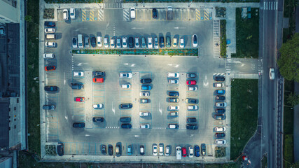 Top view of car park at night. Cars in the parking lot under the light of street lights