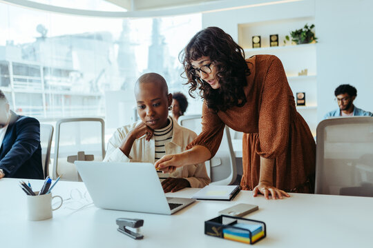 Happy business women collaborating on a creative project in a modern office